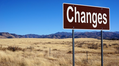 Changes road sign with blue sky and wilderness